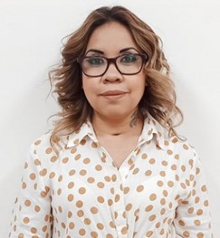 Fotografía de Ruth Francisca López, usa lentes y viste una camisa blanca con puntos beige. 